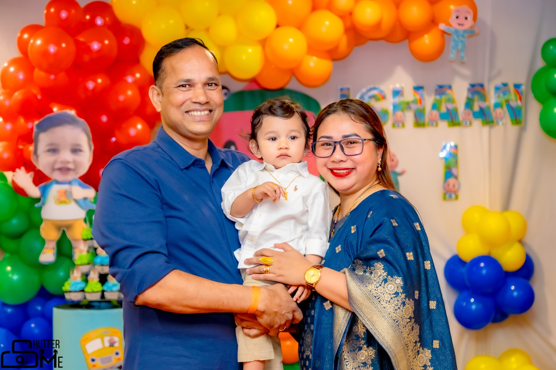 Family celebrating at a colorful first birthday party