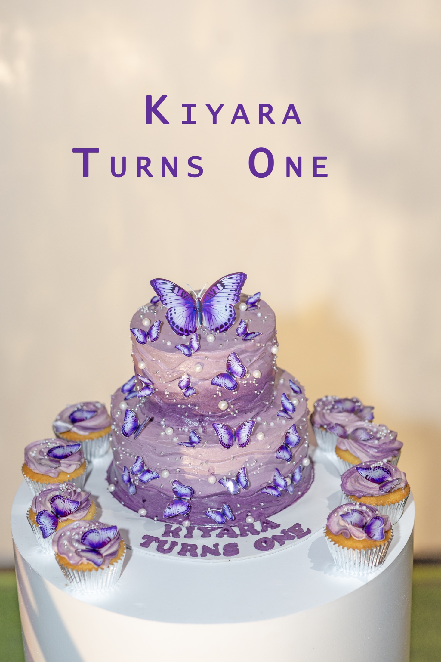 Purple butterfly first birthday cake with matching cupcakes